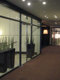 Na sliki je hodnik, kjer je uporabljena požarna zasteklitev brez profilov Promat®-SYSTEMGLAS 30 v notranjosti hotela Kempinski Palace v Portorožu, na levi strani zasteklitve so zelene rastline v velikih loncih. 